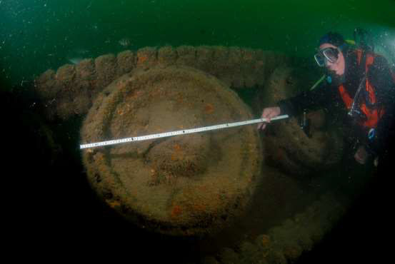 A diver measures one of the Tank road wheels